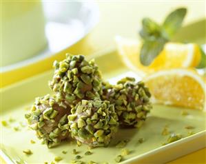 Pistachio and orange pralines on a light green tray