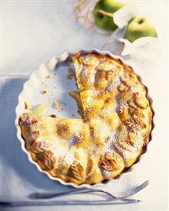 Apple pie, a piece cut, in pie dish