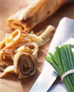 Pancake strips on chopping board, chives