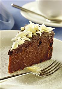 A piece of rum chocolate cake with white chocolate curls