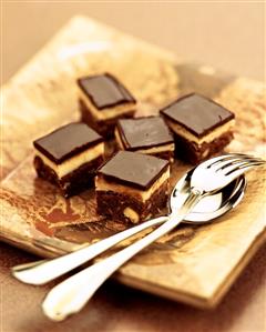 Chocolate and almond squares on a plate with cutlery