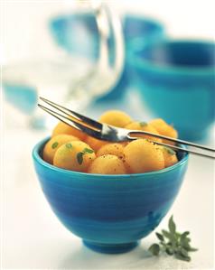 Spicy melon salad with basil in a blue bowl