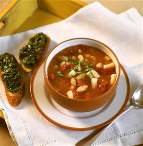 White bean soup with tomatoes, beside it bread with spinach