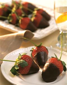 Fresh strawberries, dipped in chocolate, on a plate