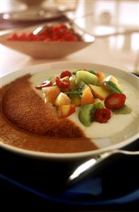 Fruit salad in ricotta mousse with cinnamon on plate