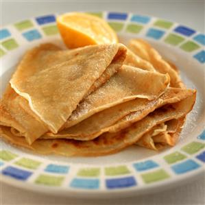 Several orange crepes on a plate