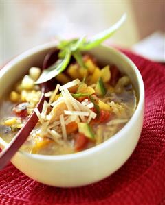 Minestrone with grated parmesan in white bowl