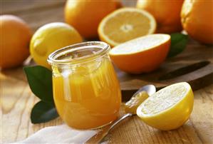 Orange jelly with lemons in jar; fresh citrus fruits