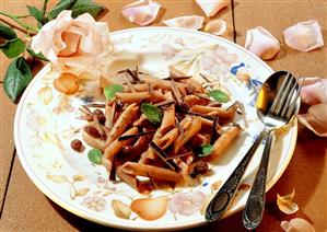 Sweet penne with chocolate sauce, raisins and mint