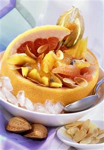 Exotic fruit with almonds in grapefruit half on ice