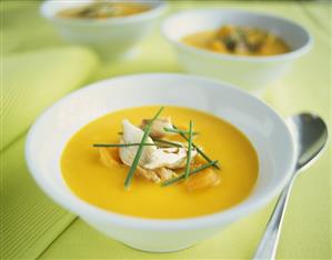 Orange and carrot cream soup with mackerel and chives