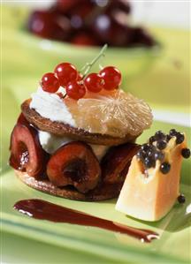 Confection with fruit and cream on a green plate