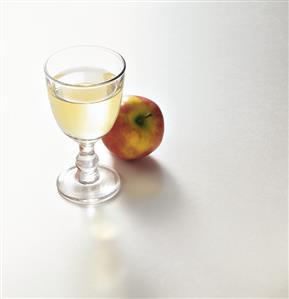 A glass of vinegar and an apple