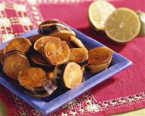 Flambeed bananas on blue plate; limes