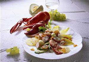 Lobster salad with fruit and chicory; white wine glass