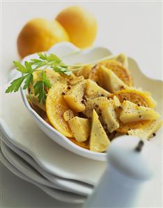 Spicy artichoke and orange salad in white bowl