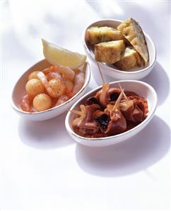 Three different tapas in white bowls