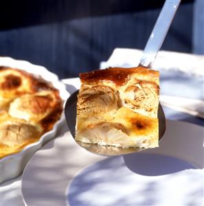 Apple & almond clafoutis on cake slice and in baking dish