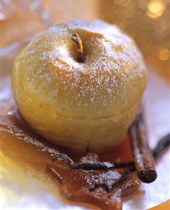 Ginger baked apples with icing sugar, caramel & cinnamon stick