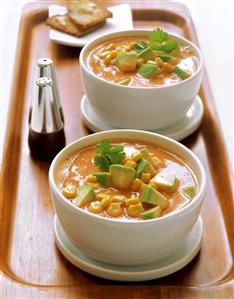 Sweetcorn and avocado soup in bowls on tray