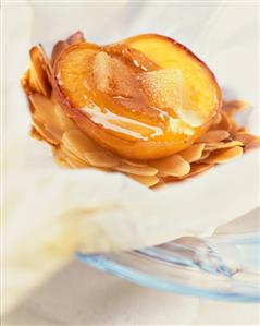 Peach on flaked almonds in baking paper