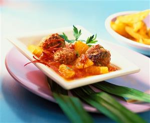 Meatballs in tomato and orange ragout with strips of chili