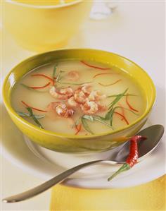 Potato soup with chili, basil strips and shrimps