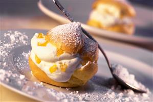 Cream puff with peaches, quark cream and icing sugar