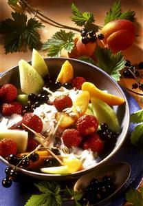 Fruit salad with cream, sunflower seeds and lemon grass