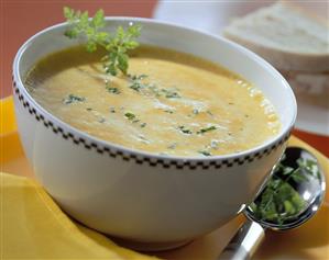 Yellow pepper soup with herb leaves