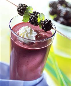 Berry shake with blob of cream and cocktail blackberry