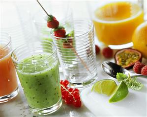 Still life with kiwi fruit- & orange juice, berries & fruit