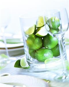 Limes in large glass container on laid table