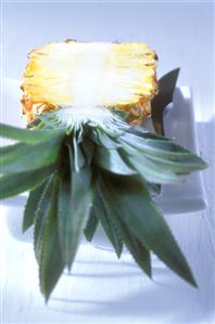 Half a pineapple on white plate