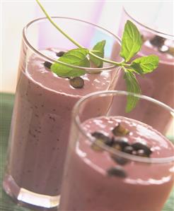 Blueberry milkshake with sprig of fresh mint