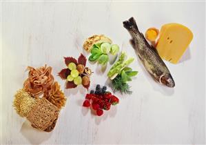 Still life: wholemeal foods, vegetables, berries, fish, cheese