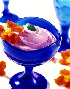 Watermelon mousse in blue bowl with edible flowers