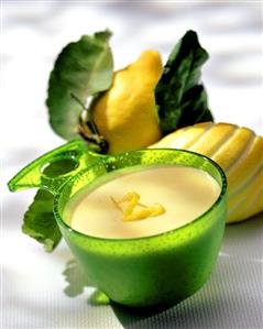 Lemon mousse in green bowl in front of lemons