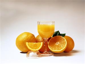 Glass of orange juice and fresh oranges