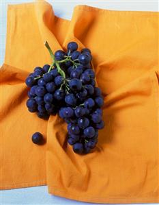 Black grapes on orange cloth