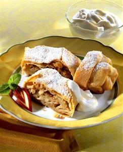 Apple and walnut strudel with cream and icing sugar