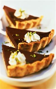 Three pieces of chocolate cake with cinnamon and cream rosettes