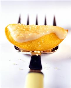 Peach wedge with lemon icing on fork