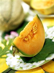 Wedge of sweet melon on coloured plate