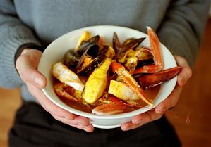 Person holding dish of bouillabaisse