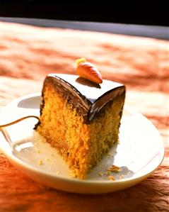 Piece of carrot cake with chocolate icing & marzipan carrot