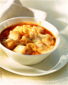 Tomato soup with fish, onions and croutons