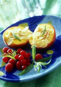 Baked peaches with flaked almonds and berries