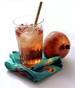 Glass of pomegranate juice with ice cubes and pomegranate seeds