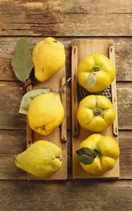 Fresh quinces on old wooden graters